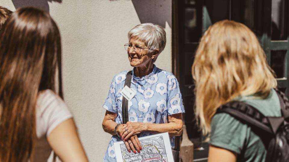 Stadtführerin erzählt zwei Damen in der Altstadt Zug Hidden Gems der Kolinstadt.