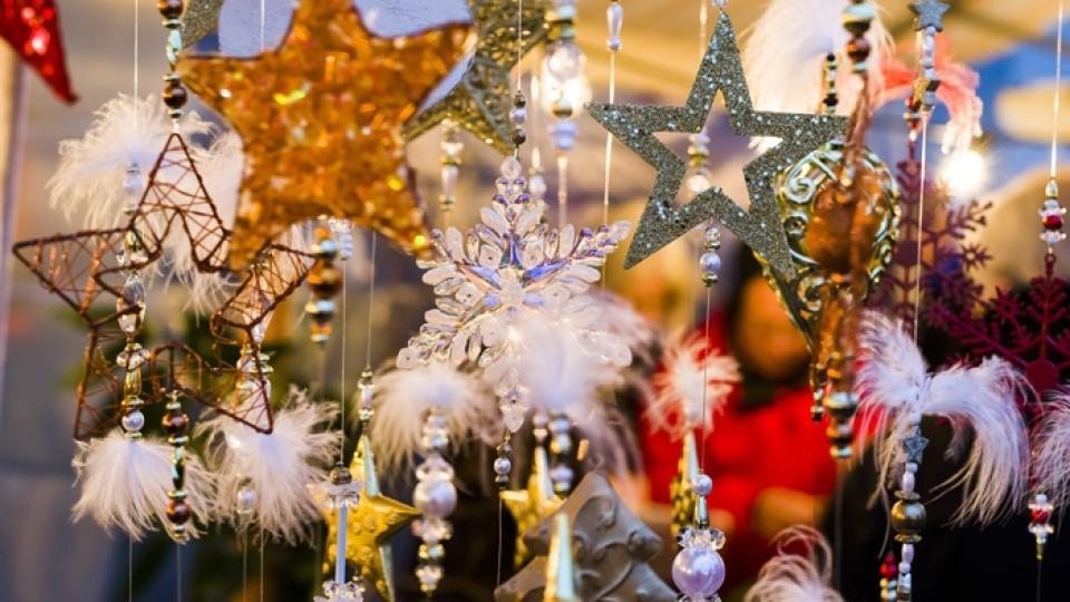 Buntes Dekomaterial für Weihnachten hängt an einem Stand des Neuheimers Weihnachtsmarkt.