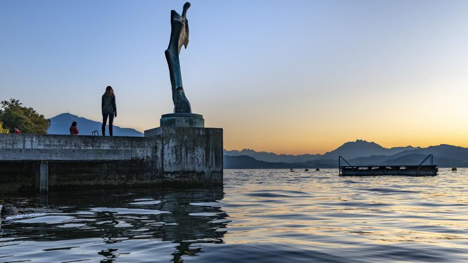 Die Skulptur steht am See mit der Rigi und dem Pilatus im Hintergrund.